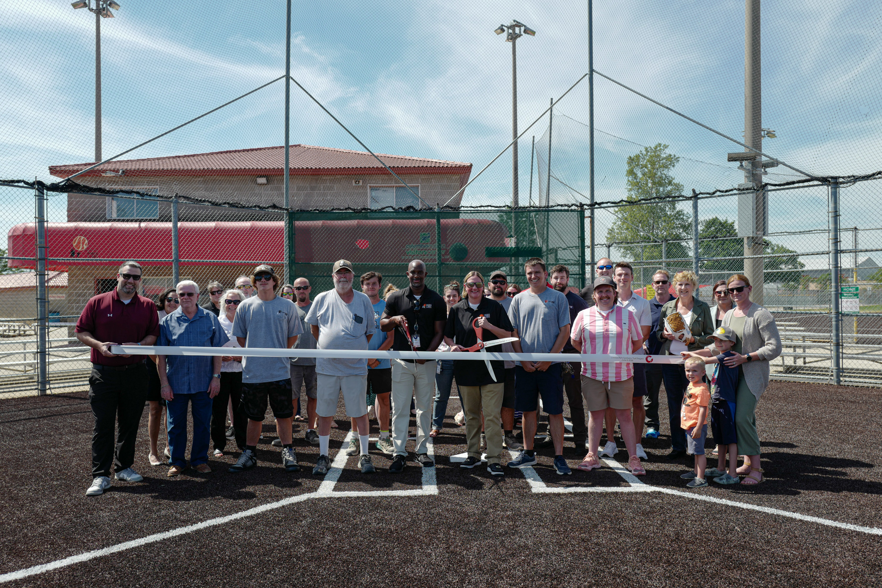 City and community representatives participate in a ribbon cutting ceremony to officially open the newly turfed fields at Lincoln Park in Columbus, Indiana.